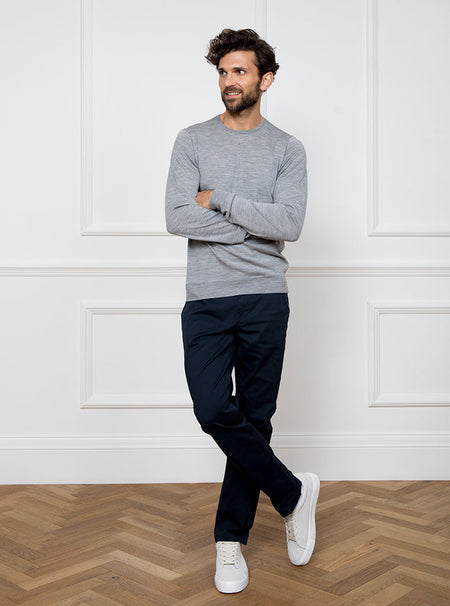 Man wearing silver grey long sleeved crewneck sweater knit in 100% luxury and premium merino wool.